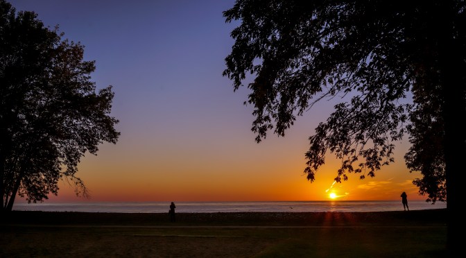 Strangers taking-in the picture perfect sunrise over Lake Ontario
