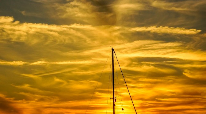 Sun setting across sailboat in Sea of Abaco, Bahamas