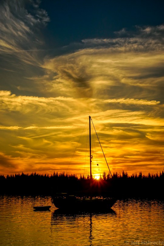 sun setting across sailboat in sea of abaco bahamas
